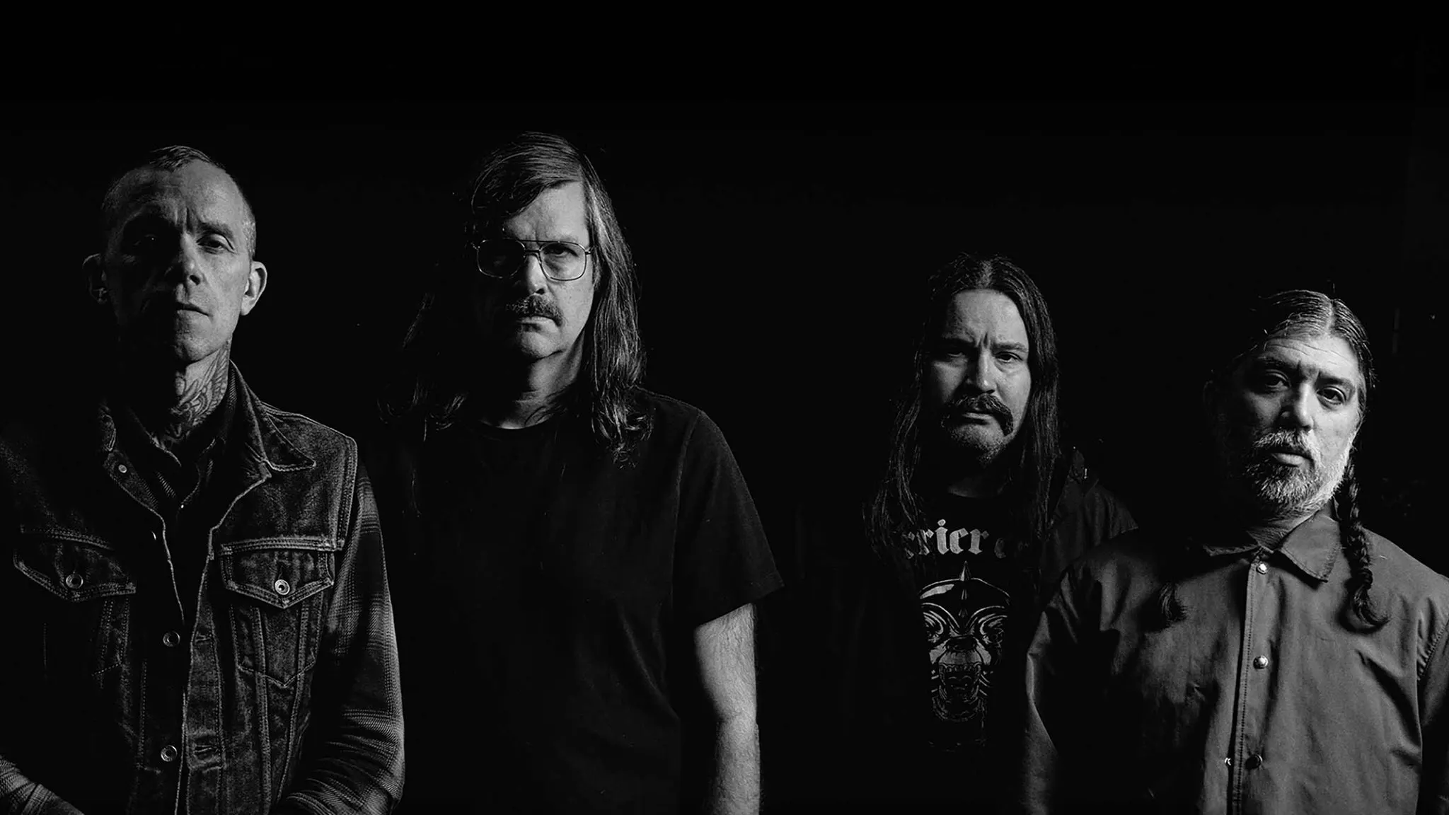 Black and white portrait of the four members of Converge standing against a dark background, ahead of their El Corazon show near Grappa