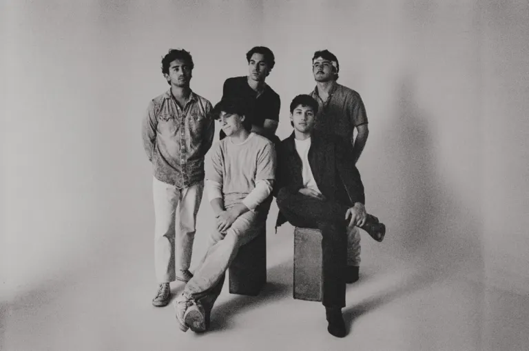 Black and white studio photo of the five members of WEST 22ND, two seated on low blocks and three standing behind them, ahead of their Nectar Lounge show near Grappa